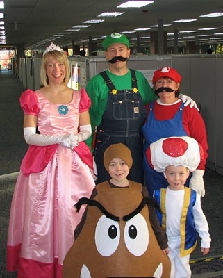 a group of people dressed up as mario bros and princess peach, including two children