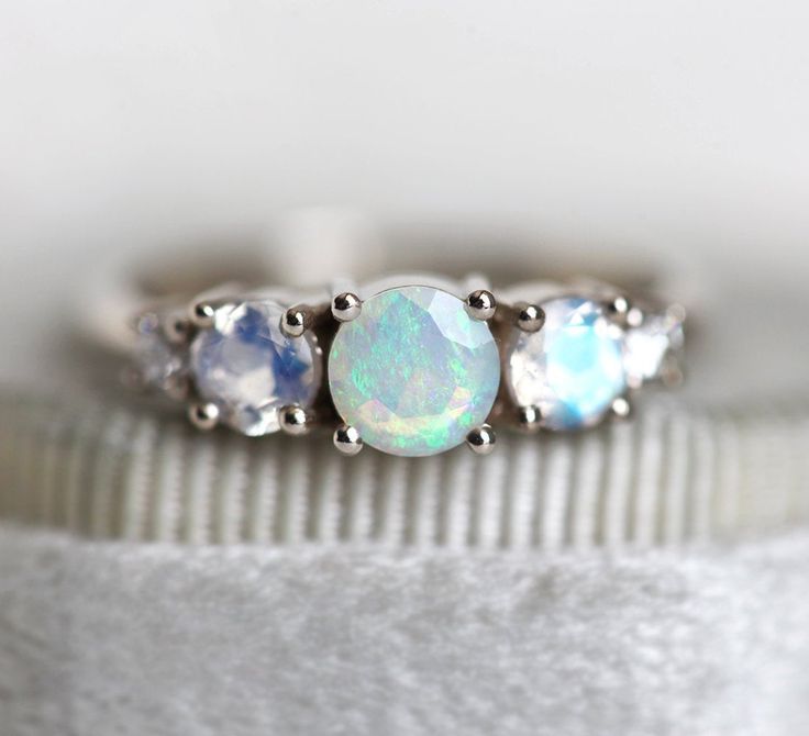 three stone ring with opal and white topazte stones in the middle, set on