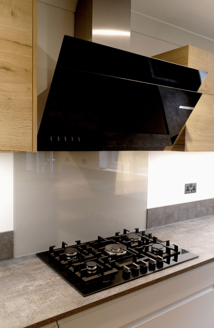 a black stove top oven sitting inside of a kitchen next to wooden cabinets and counter tops