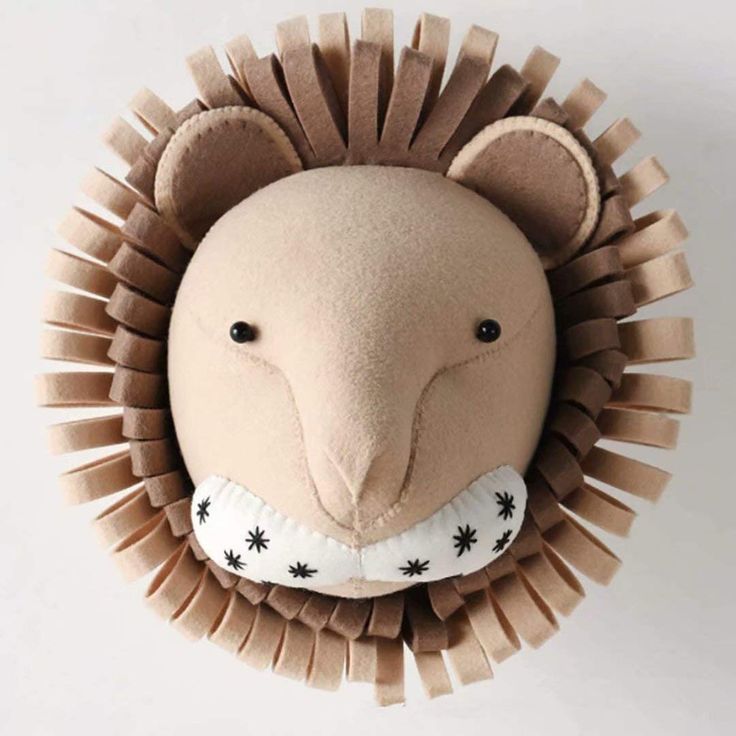 a stuffed animal that looks like a lion's head is hanging on the wall