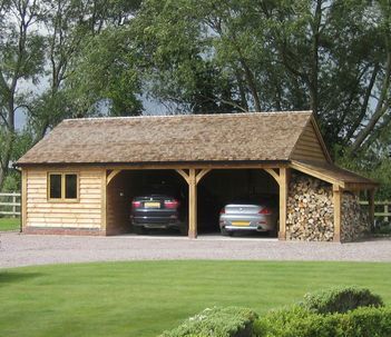 two cars are parked in front of a wooden garage with logs stacked on the roof