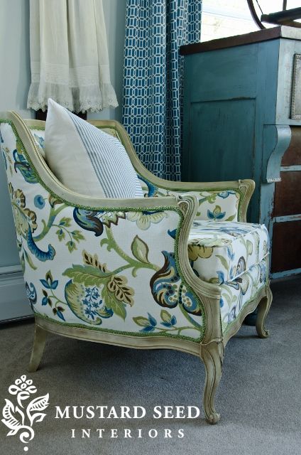 a chair sitting in front of a window next to a dresser with curtains on it