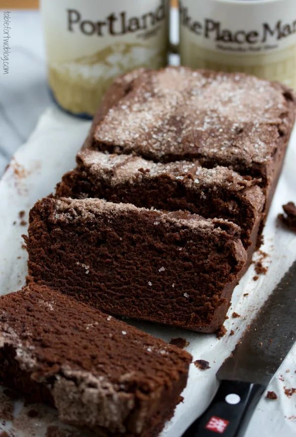 chocolate cake with powdered sugar on top next to knife and jar of frosting