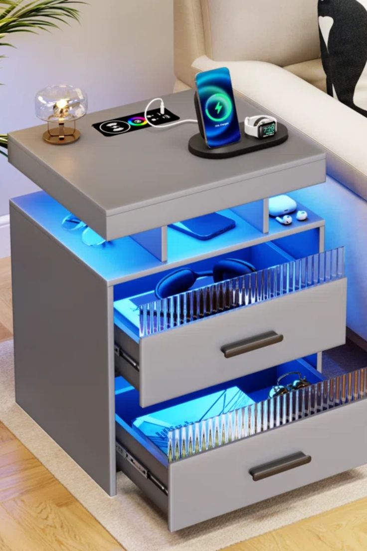 a table with two drawers that are lit up in blue light, and the bottom drawer is open