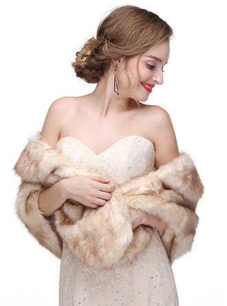 a woman in a white dress is wearing a fur stole