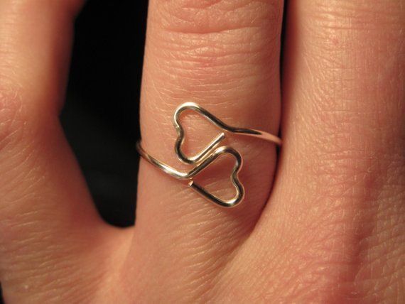 a close up of a person's hand with a heart shaped ring on it