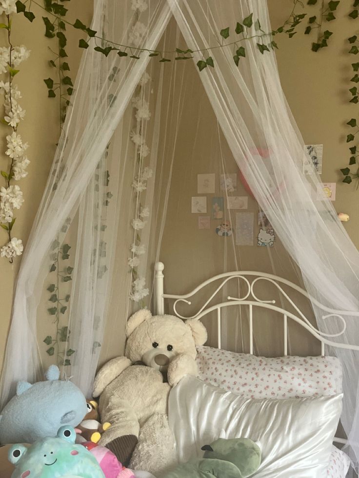 there are stuffed animals on the bed in this child's room with mosquito netting