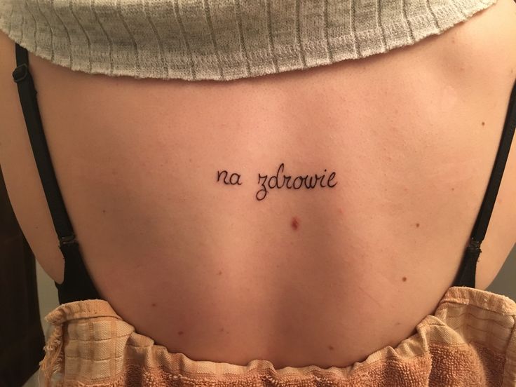 a woman with a tattoo on her back saying, no glitawre in cursive writing