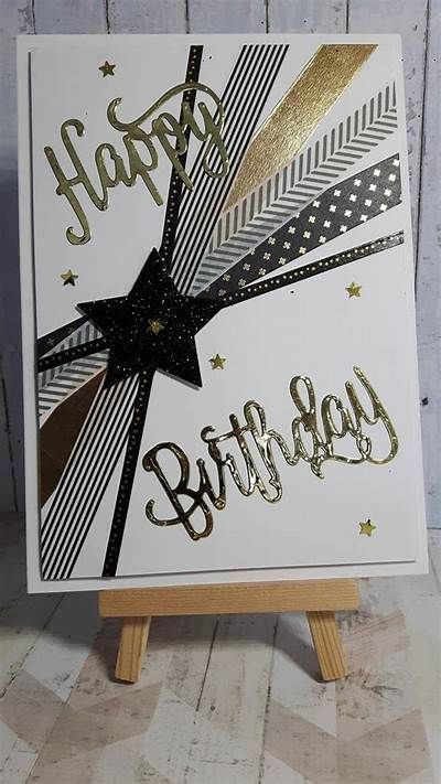 a happy birthday card with gold foil and black ribbon on it, sitting on top of a wooden easel