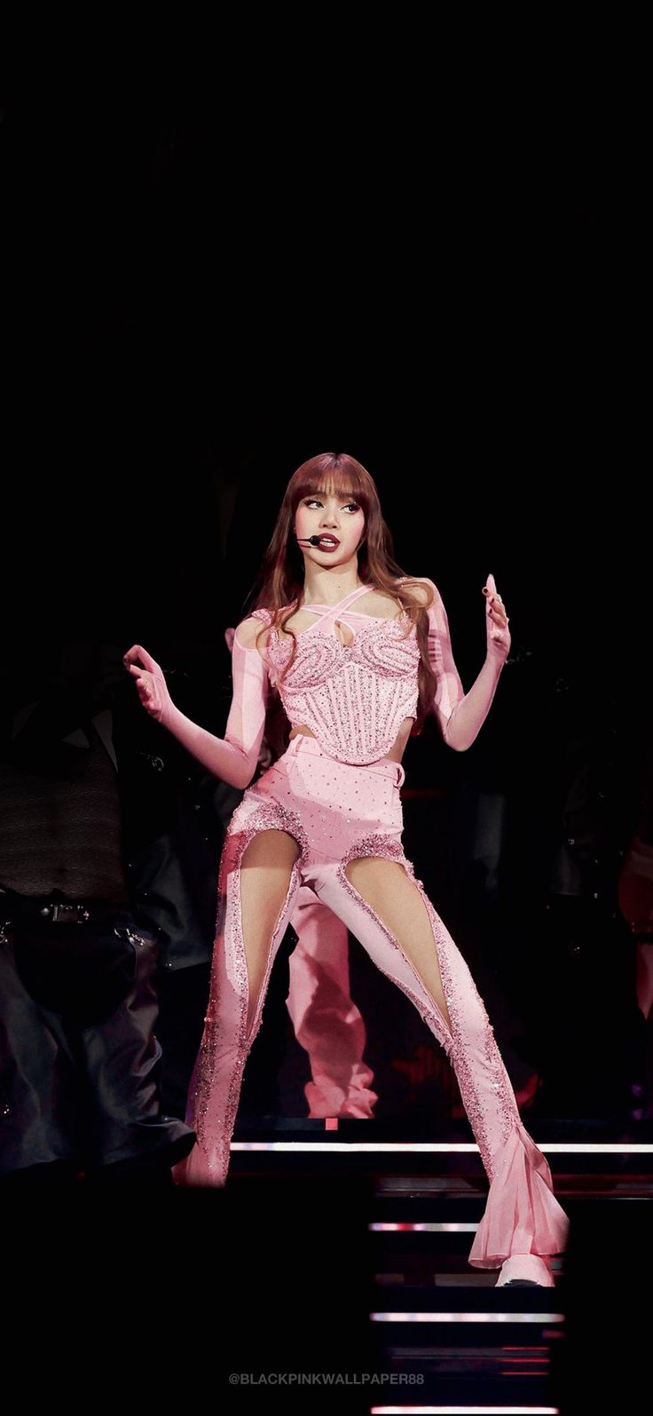 a woman in a pink outfit is performing on stage