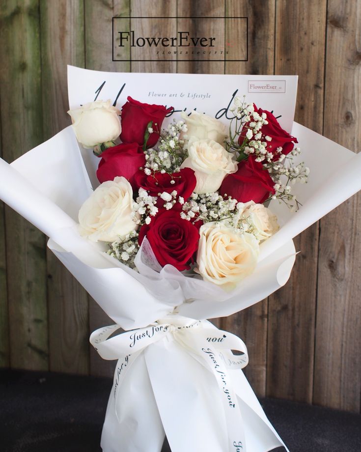 a bouquet of roses wrapped in white paper