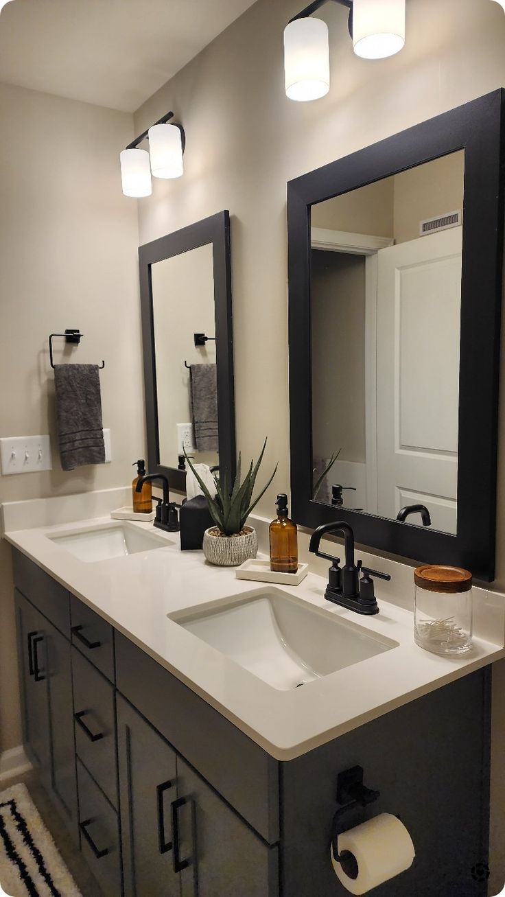 a bathroom vanity with two sinks and mirrors