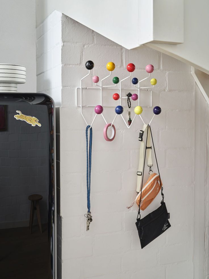 a white brick wall with various items hanging from it's hooks on the wall