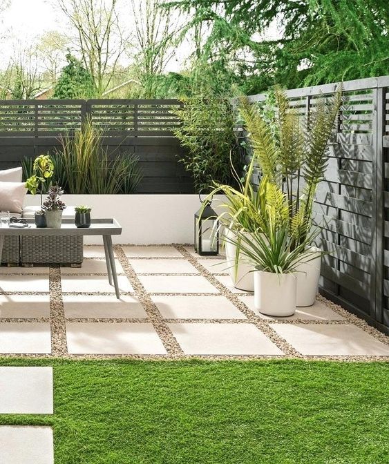 an outdoor living area with grass and potted plants