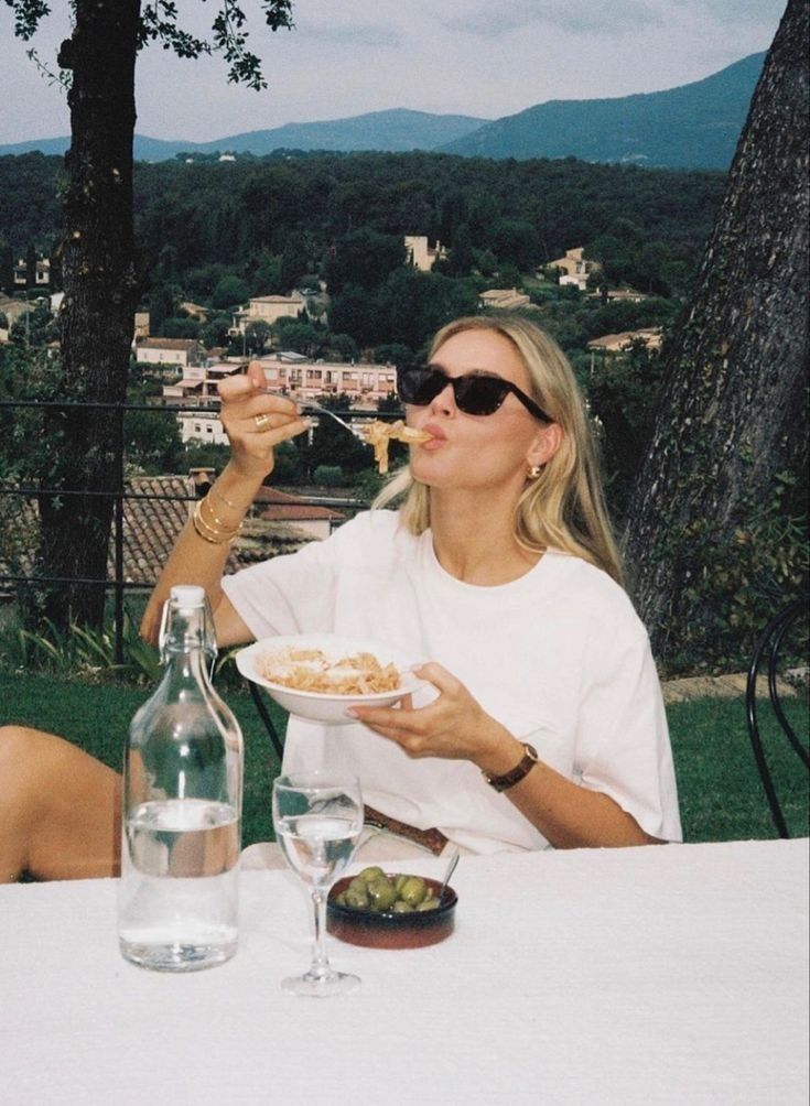 a woman sitting at a table eating food