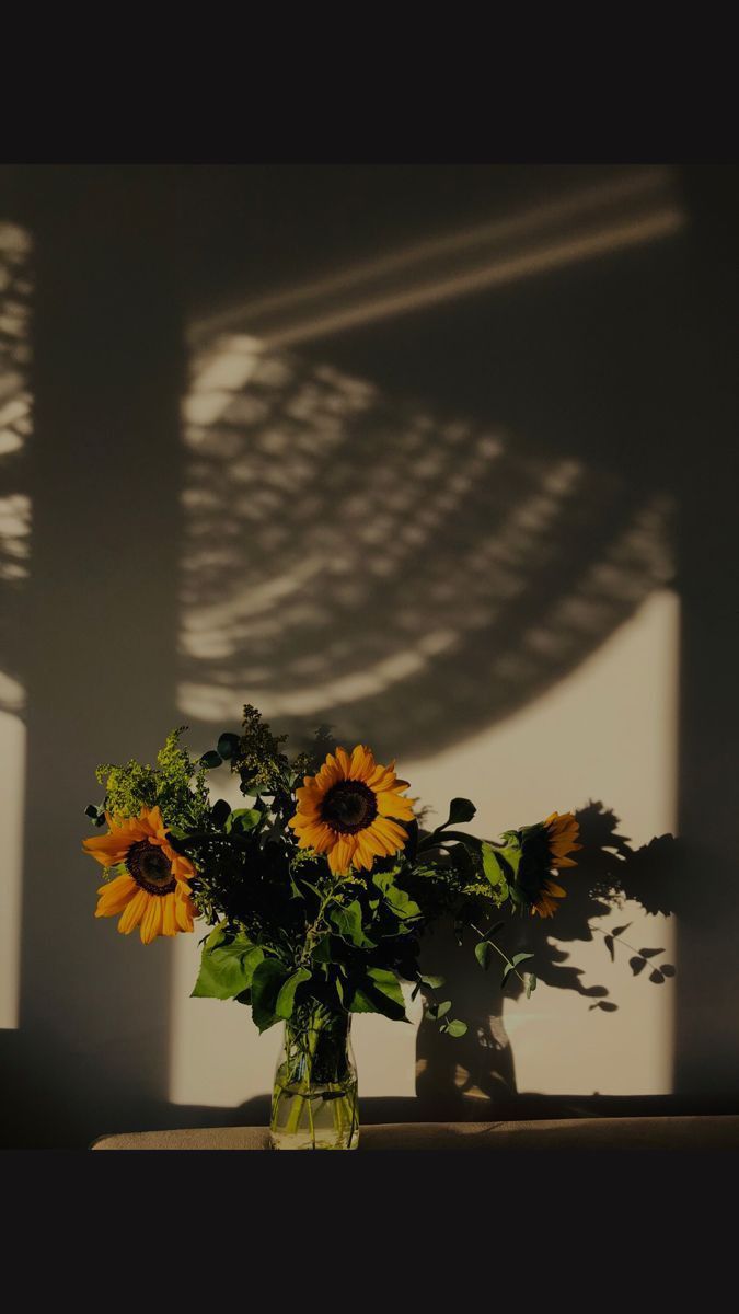 a vase filled with sunflowers on top of a table