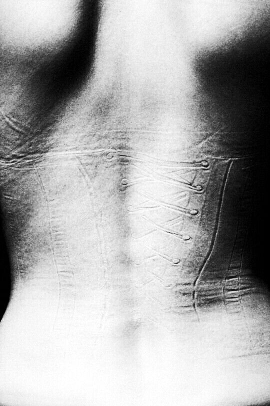 a black and white photo of the back of a woman's body with lines drawn on it