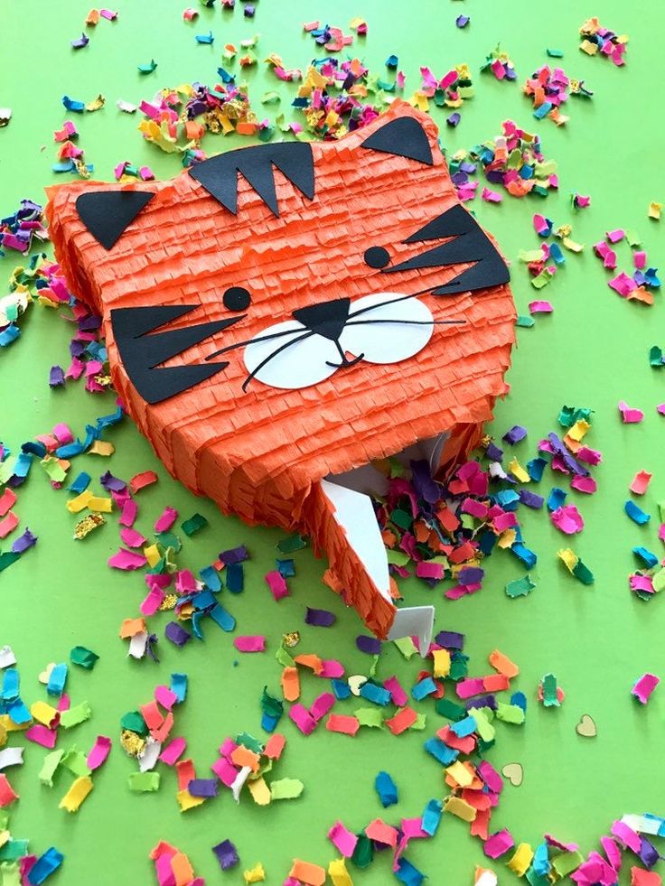 an origami cat head surrounded by confetti