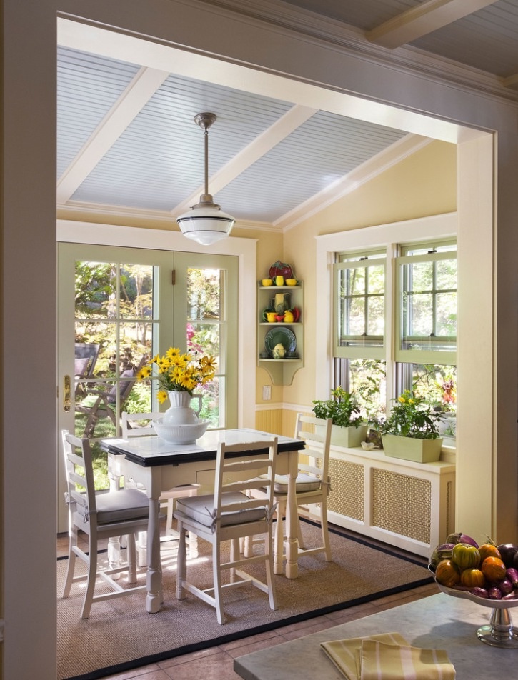 an open kitchen and dining room area with sun shining through the windows on the wall