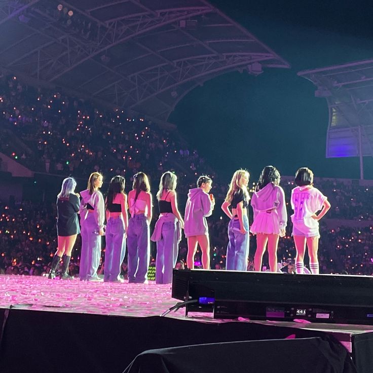 a group of women standing on top of a stage next to each other in front of a crowd