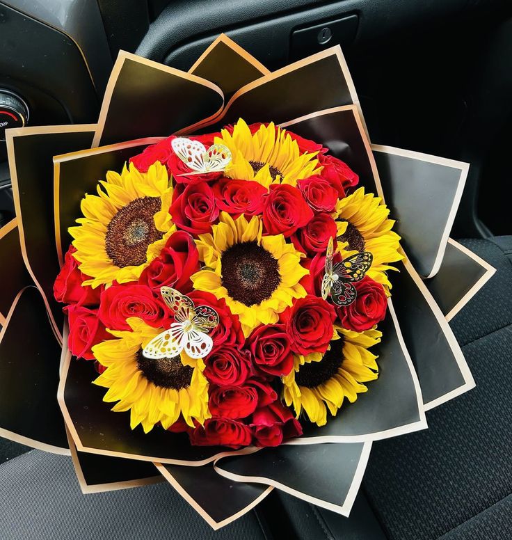 a bouquet of sunflowers and roses in the back seat of a car