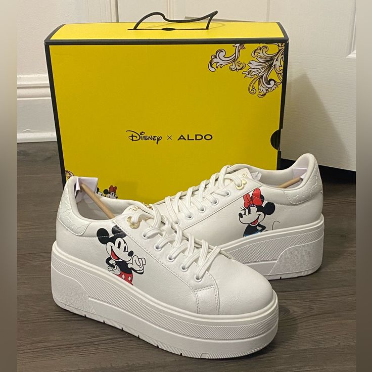 The D100z Sneakers From Aldo X Disney Collection Lace A Low-Top Silhouette With Colorful Characters Atop Chunky Platforms For A Strikingly Sporty Boost To Any Look. 3" Platform Heel Round-Toe Lace-Up Platform Sneakers Graphic Detailing At Upper Pillow Walk Comfort Technology With Dual Density Foam To Help Absorb Impact And Cushioning For Added Comfort Manmade Upper; Polyester Lining; Leather Sole White Disney Sneakers In Synthetic Material, White Sporty Mickey Mouse Sneakers, Disney White Sneakers With Mickey Mouse, Disney White Low-top Sneakers, Aldo Disney Shoes, Black And Gold Sneakers, Shoes Disney, Fashion Tennis Shoes, Colorful Characters