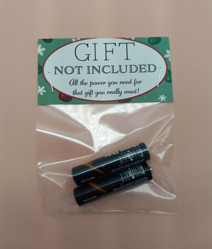 two black batteries sitting on top of a plastic bag next to a package with the words, gift not included