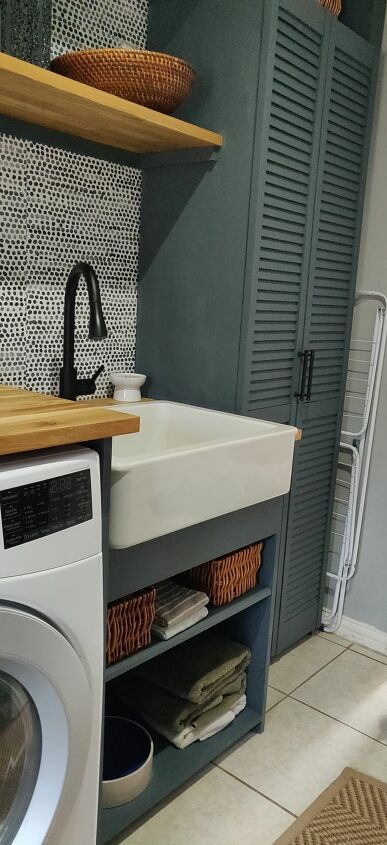 a washer and dryer in a small room with shelves on the wall behind them