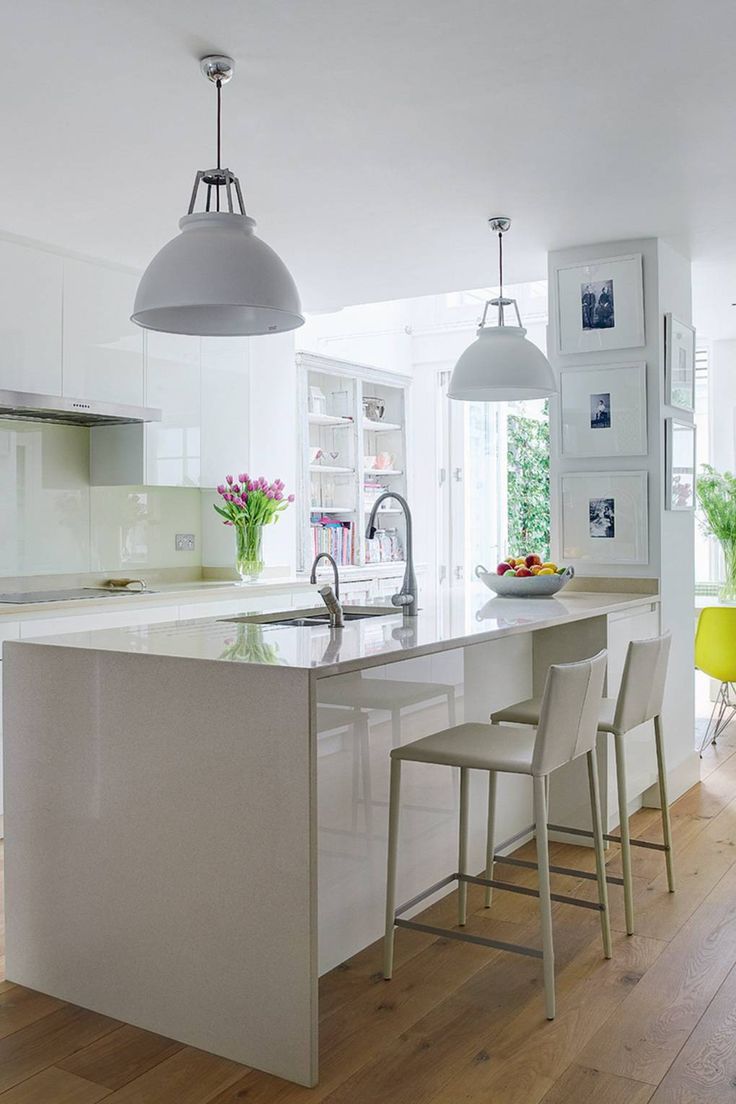 a kitchen with an island and chairs in the middle of it, next to a dining room table