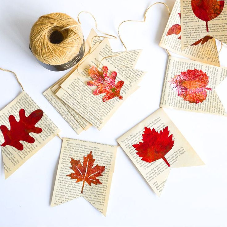 autumn leaves are displayed on top of an old book page with twine spools