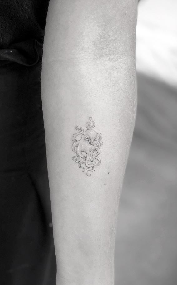 a woman's arm with a tattoo on it that has an octopus in the middle