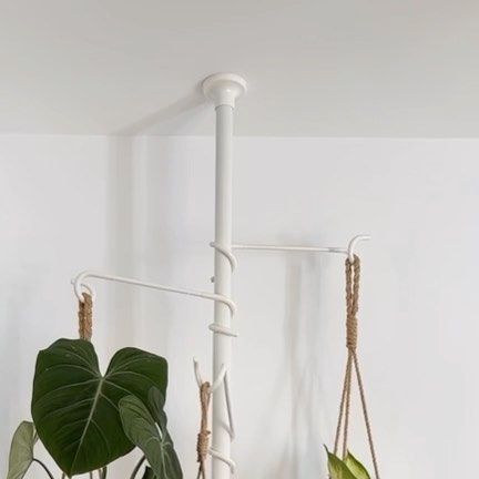 three hanging planters with plants in them on a shelf next to a white wall