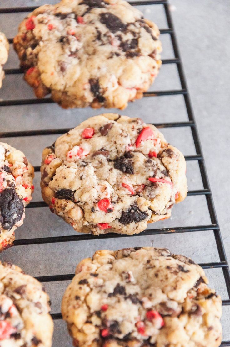 chocolate chip cookies cooling on a rack with red and white sprinkles in the middle