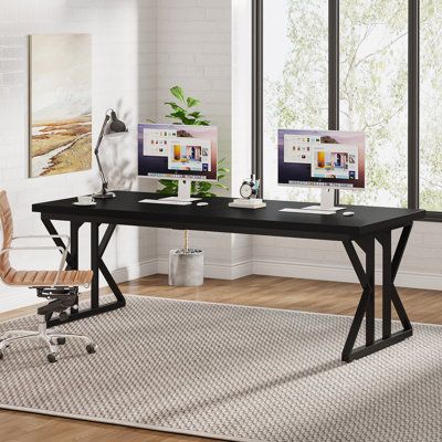 a computer desk with two monitors and a chair in front of it on top of a rug