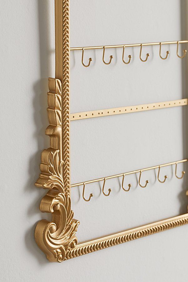 there is a gold metal rack with hooks on it