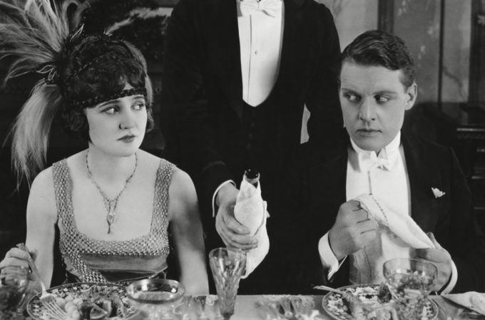 a man and woman sitting at a dinner table