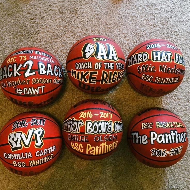 six basketballs with different logos on them sitting on the floor next to each other