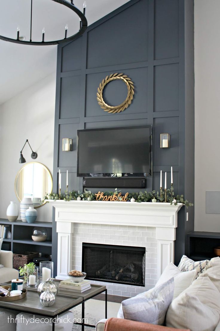 a living room filled with furniture and a flat screen tv mounted on the wall above a fireplace