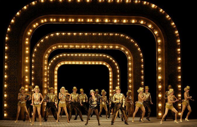 a group of people that are standing in front of some light up arches with lights on them