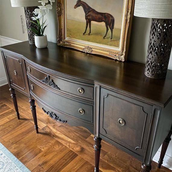 a horse painting on the wall behind a dresser