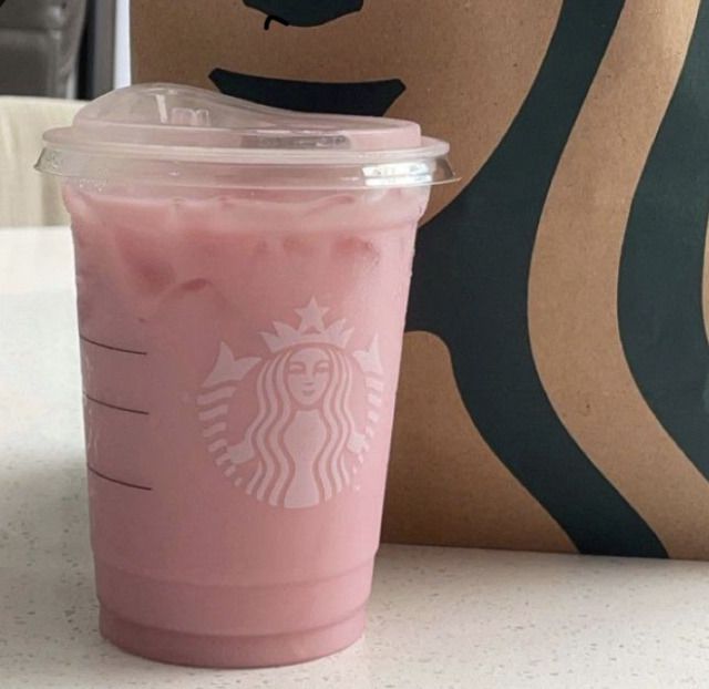 a pink drink sitting on top of a table