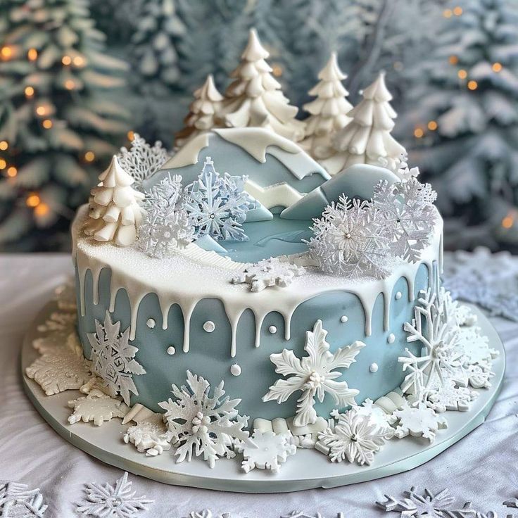 a frosted christmas cake with trees and snowflakes on the top is sitting on a table