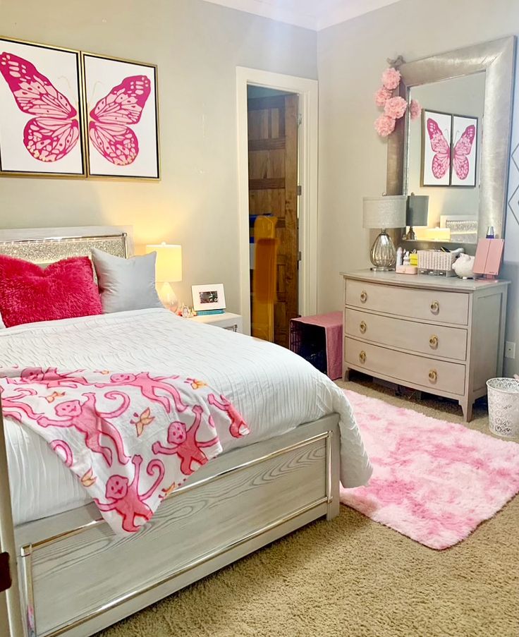 a bedroom decorated in pink and white with butterfly decorations on the wall above the bed