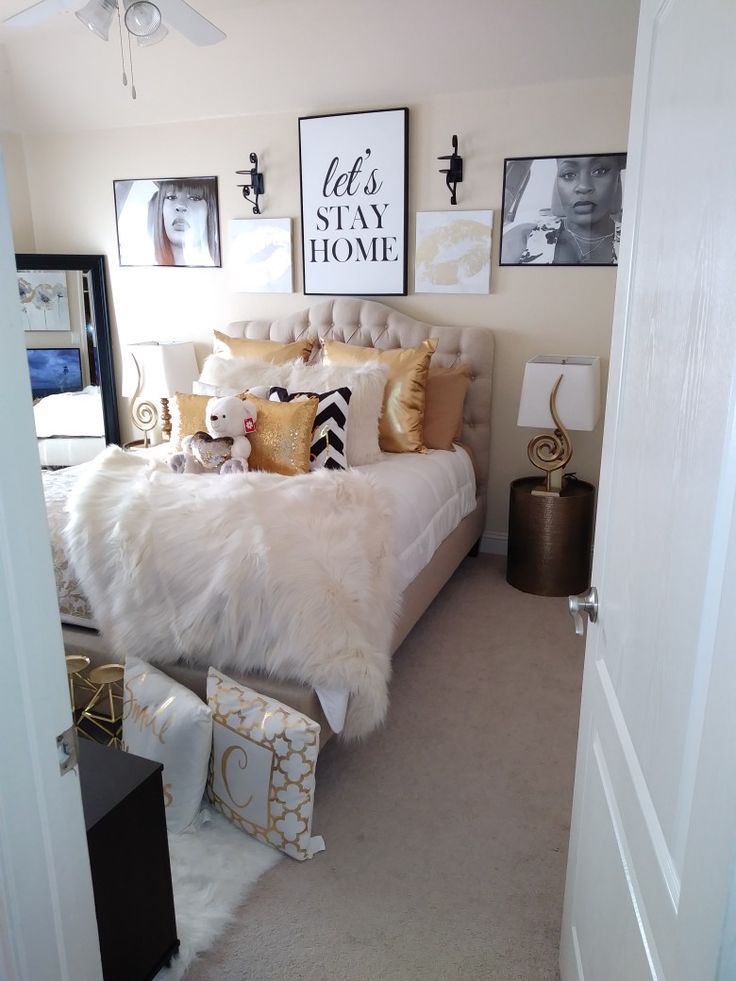 a white bed sitting in a bedroom next to a doorway with pictures on the wall