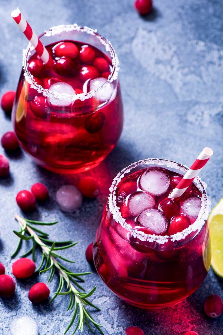 two glasses filled with cranberry punch and garnished with ice