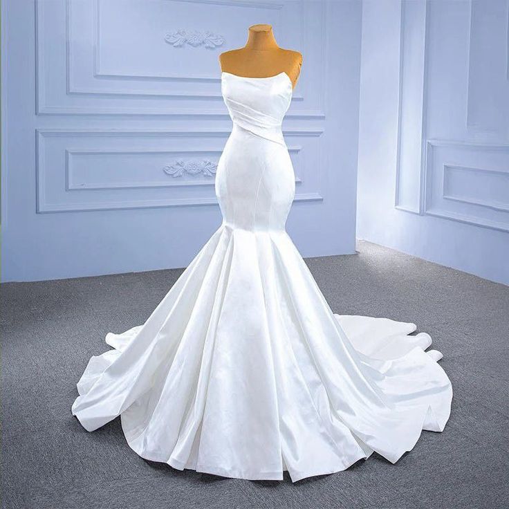 a white wedding dress on display in a room