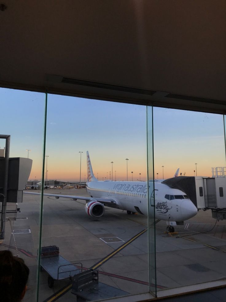 an airplane sitting on the tarmac in front of a window at an air port