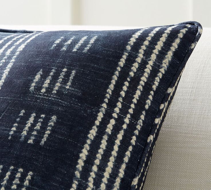 a blue and white pillow sitting on top of a couch