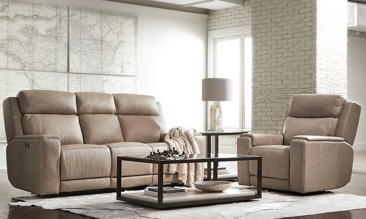 a living room with two recliners and a coffee table in front of a brick wall