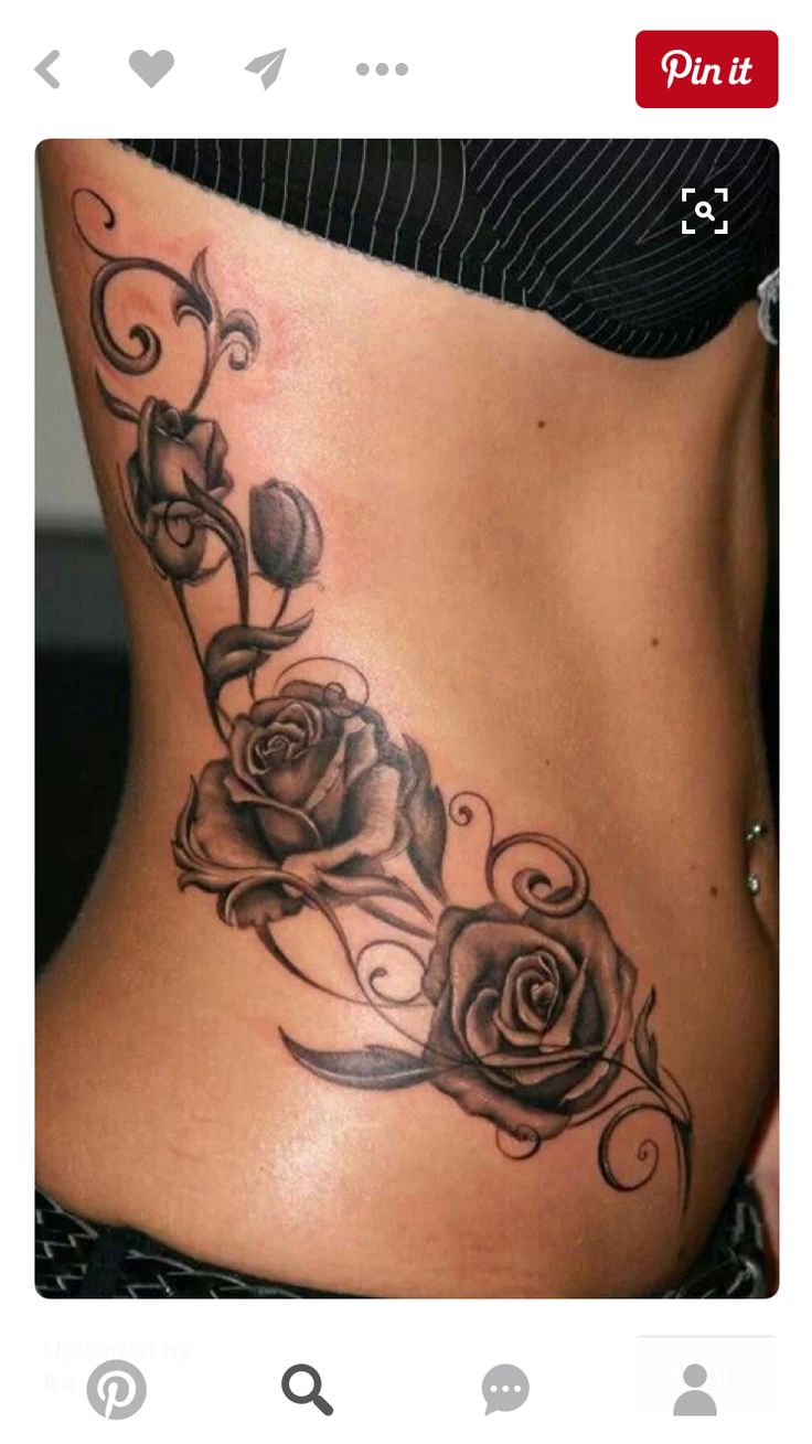 black and white photo of a woman's stomach with roses on the side tattoo